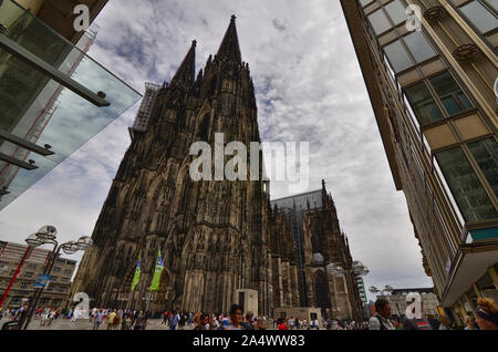 Colonia, agosto 2019. L'imponente facciata della cattedrale mostra il ponteggio per la manutenzione continua. Alla base di molti turisti. Foto Stock