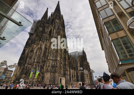 Colonia, agosto 2019. L'imponente facciata della cattedrale mostra il ponteggio per la manutenzione continua. Alla base di molti turisti. Foto Stock