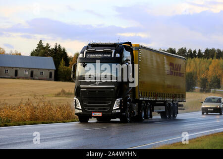 Nero Volvo Truck FH di Towerline Oy tira DHL semi rimorchio lungo l'autostrada in autunno il tramonto. Salo, Finlandia. Il 4 ottobre 2019. Foto Stock