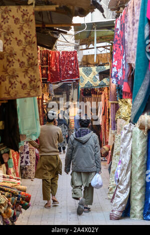 A Peshawar, Pakistan - Gennaio 1, 2015: vestiti appesi per un display nella strada stretta di Shaheen bazaar nella parte vecchia della città di Peshawar. Foto Stock