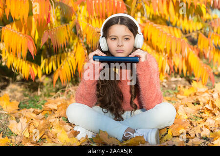 Oggi eLearning. Bambina imparare online sotto agli alberi con foglie di giallo. Bambino Piccolo elearning sulla soleggiata giornata autunnale. L'istruzione globale. eLearning per il futuro ambiente eLearning. Foto Stock