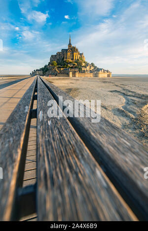 Strada che conduce al Mont Saint Michael con la sua abbazia e la bassa marea Foto Stock