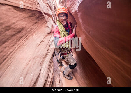 Canyoneer con fune spreme attraverso una sezione di tenuta nello slot canyon Foto Stock
