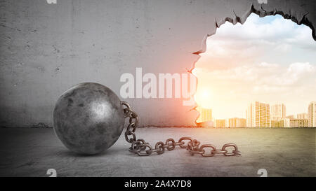 Un nero wrecking ball e un foro in un muro di cemento che mostra il paesaggio della città. Foto Stock