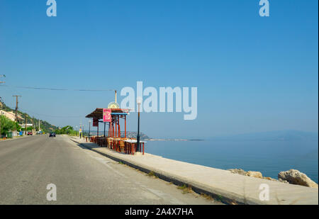 Xilokastra Grecia - Luglio21 2019; Ristorante tavoli e sedie sul sentiero lungo il mare e tra il mare e l'autostrada. Foto Stock