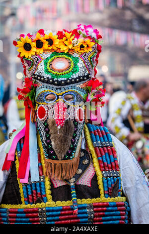 Mummers eseguire rituali per spaventare gli spiriti malvagi a Surva festival di Pernik in Bulgaria. Le persone sono chiamati Kuker, kukeri.molto colorato e lucido mas Foto Stock