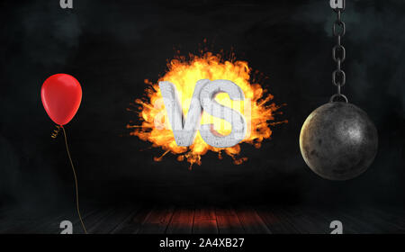 3D rendering di un calcestruzzo lettere VS circondata dal fuoco stand tra una celebrazione rosso palloncino e una palla di demolizione. Foto Stock