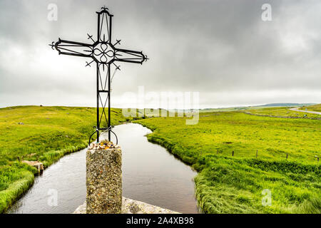 Una croce di ferro è stata eretta su un ponte del pellegrinaggio a Santiago de Compostela. Domina il fiume Bes che scorre sull'altopiano di Aubrac Foto Stock