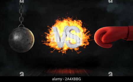 3D rendering di un calcestruzzo lettere VS ha preso fuoco tra una palla di demolizione di rosso e un guanto di boxe. Foto Stock