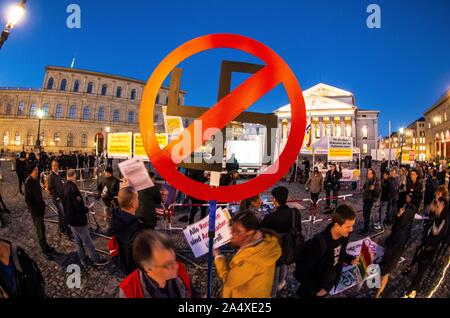 Monaco di Baviera, Germania. Xvi oct, 2019. Un dimostrante contro Michael Stuerzenberger detiene una svastica che è barrata. Colleauges di Stuerzenberger sono state associate con neonazis e l'antisemitismo. Nonostante la recente condanna per istigazione delle masse, islamophobe Michael Stuerzenberger organizzato una dimostrazione sotto il Buergerbewegung Pax Europa banner a Monaco di Baviera Max Joseph Platz. Almeno una denuncia penale contro Chris K., Stuerzenberger's assistant è stato archiviato a causa di insulti un dimostratore. Credito: Sachelle Babbar/ZUMA filo/Alamy Live News Foto Stock