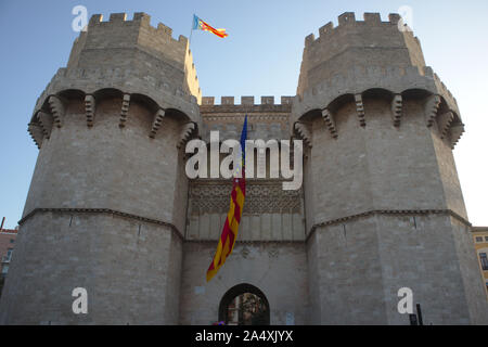Close-up delle Torri di Serranos nella città di Valencia dal quale pende una grande bandiera della Comunità Valenciana Foto Stock
