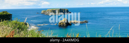 Vista panoramica delle isole rocciose sull'oceano turchese, scogliere di Irlanda del Nord Foto Stock