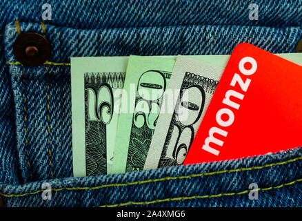 Monzo carta bancaria e le fatture del dollaro nella tasca dei jeans. Foto macro. Foto Stock