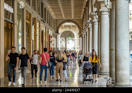 Persone che passeggiano attraverso il marmo portici di Via Roma , una delle principali aree dello shopping di Torino, Italia Foto Stock