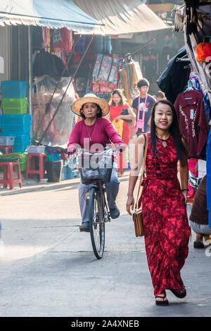 Mae Sot, Tailandia - 3 Febbraio 2019: Donne in bicicletta e a piedi in strada. Ci sono dei gruppi etnici nell'abitato. Foto Stock