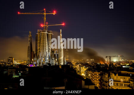 Barcellona, in Catalogna, Spagna. Xvi oct, 2019. La Sagrada Familia è visto nella notte come il fumo di masterizzazione di barricate sorge sopra la città di Barcellona durante il terzo giorno di proteste dopo che la Corte suprema spagnola ha dichiarato alla frase di nove indipendentista catalano leader di 9-13 anni in prigione. Credito: Jordi Boixareu/ZUMA filo/Alamy Live News Foto Stock