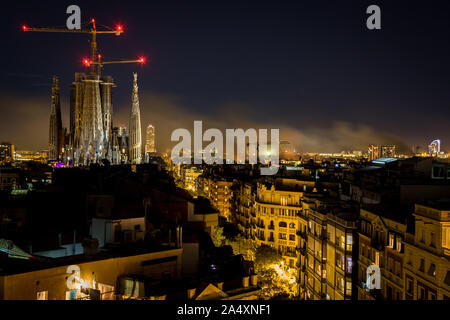 Barcellona, in Catalogna, Spagna. Xvi oct, 2019. La Sagrada Familia è visto nella notte come il fumo di masterizzazione di barricate sorge sopra la città di Barcellona durante il terzo giorno di proteste dopo che la Corte suprema spagnola ha dichiarato alla frase di nove indipendentista catalano leader di 9-13 anni in prigione. Credito: Jordi Boixareu/ZUMA filo/Alamy Live News Foto Stock