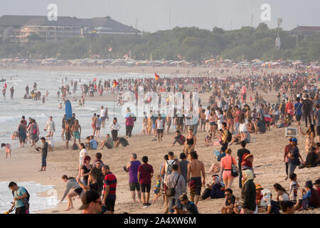 Una grande folla di persone sulla spiaggia di Kuta Beach a Bali, in Indonesia Foto Stock