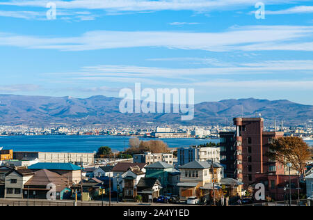 Dicembre 2, 2018 Hakodate, Giappone - Hakodate blu baia del porto e la città di edifici residenziali con vista montagna e cielo blu. Visto da di Motomachi park i Foto Stock