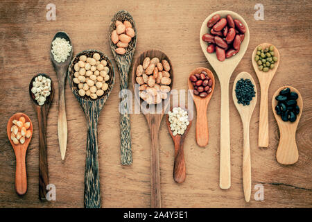 Assortimento di fagioli e lenticchie in cucchiaio di legno su legno di teak dello sfondo. Mung bean, arachide, soia, fagioli fagioli , fagiolo nero ,sesame, mais ,ri Foto Stock