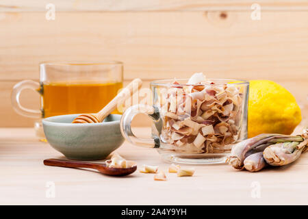 Tazza di tè alle erbe con secchi lemon grass ,miele e limone su sfondo di legno. Foto Stock