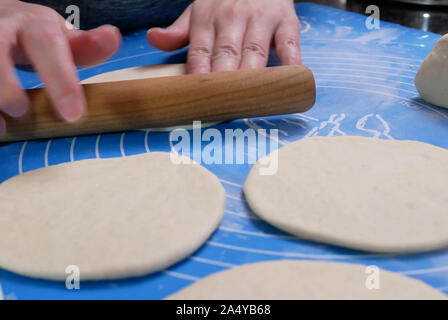 Il movimento di persone a impastare la pasta e la sagomatura con le loro mani a vapore bun a casa Foto Stock