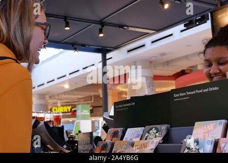 Il moto del barista prendendo ordine per il cliente al negozio Starbucks Foto Stock