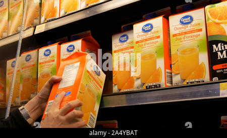 Movimento della donna acquisto di grande valore di succo d'arancia all'interno Walmart store Foto Stock