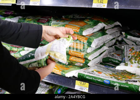 Movimento della donna acquisto di grande valore e il gigante verde verdure miste all'interno Walmart store Foto Stock