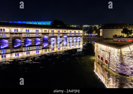 Vista notturna di illuminato diga Vauban a Strasburgo, in Francia, un lavoro difensivo sul fiume Ill nella Petite France storico quartiere. Foto Stock