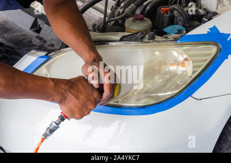 Mechanic la mano di lucidatura è la vettura del faro. Foto Stock