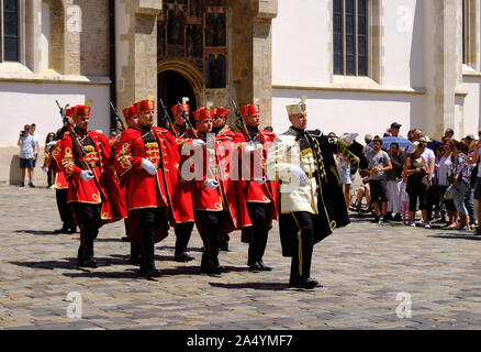 Zagabria, Croazia - Royal Cravats del reggimento di soldati a piedi giù per la strada dopo il cambio della guardia di fronte la chiesa di San Marco Foto Stock