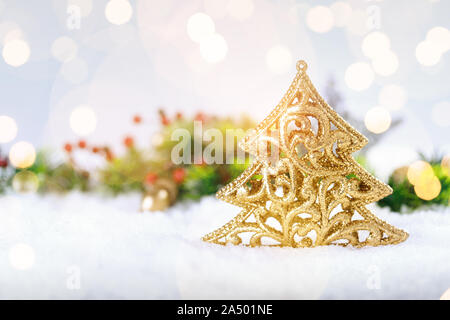 Natale albero d'oro decorazione su neve vera all'esterno. Vacanze invernali concetto. Profondità di campo Foto Stock