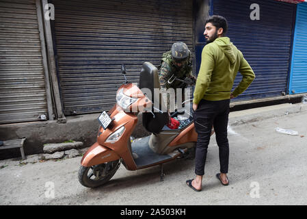 Srinagar, Jammu e Kashmir in India. Xii oct, 2019. Un indiano trooper ispeziona un motociclo dopo una granata blast in Srinagar.almeno 7 persone sono rimaste ferite dopo una granata esplosione presso il centro città Lal chowk, Srinagar capitale estiva dell indiano Kashmir amministrato. Credito: Idrees Abbas SOPA/images/ZUMA filo/Alamy Live News Foto Stock