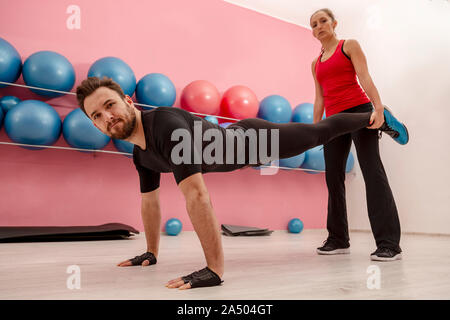 Coppia giovane facendo esercizi in palestra Foto Stock