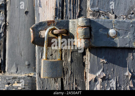 Vista ravvicinata di un vecchio lucchetto sulla porta di legno Foto Stock