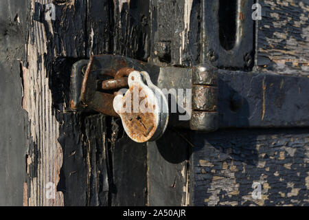 Vista ravvicinata di un vecchio lucchetto sulla porta di legno Foto Stock