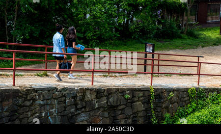 Madre e figlia teenager walking percorso di pietra con rotaie di rosso accanto a Chesapeake e Ohio Canal in Georgetown DC Foto Stock