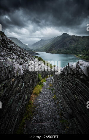 Vista di Llyn Peris da Dinorwic Quarry su un moody pomeriggio nel Parco Nazionale di Snowdonia, Wales, Regno Unito Foto Stock