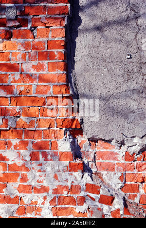 In mattoni rossi la superficie della parete con il cemento grigio, grunge verticale sfondo squallido Foto Stock