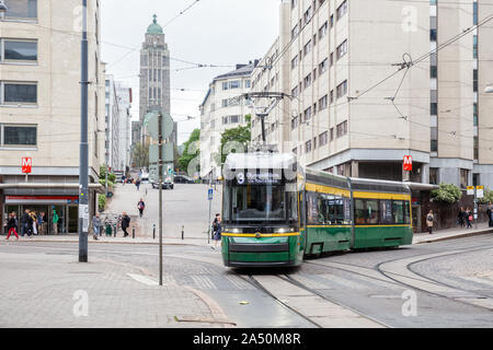 HELSINKI, Finlandia - 23 Maggio 2019: Nuovo verde tram Skoda sulla strada di Helsinki si ritorce contro lo sfondo della Chiesa Kallio Foto Stock