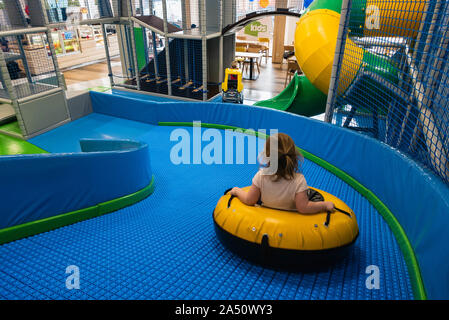 Bambina corse nella ruota sulla slitta nel giocare i bambini centro. Foto Stock