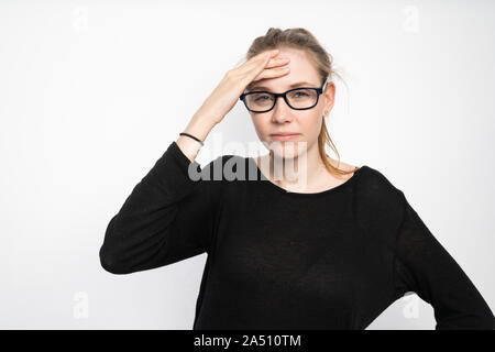 Una giovane donna mantiene la sua testa a causa del mal di testa Foto Stock