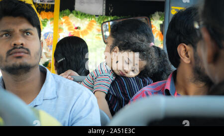 MYSURU (MYSORE),KARNATAKA/India-febbraio 18 2018:Un giovane bambino indiano dorme in esso le madri bracci su un affollato autobus di città. Foto Stock