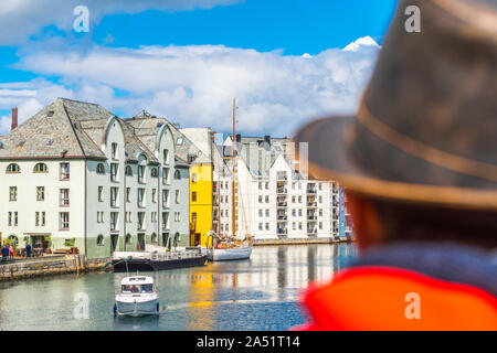 Vista posteriore dell'uomo ammirando gli edifici Art Nouveau lungo Brosundet Canal, Alesund, More og Romsdal county, Norvegia Foto Stock