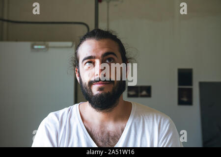 Ritratto di un giovane uomo di colore marrone con barba nera e gli occhi castani, sorridente Foto Stock