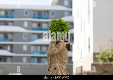 Giovane donna al di fuori di un insalata come capo Foto Stock