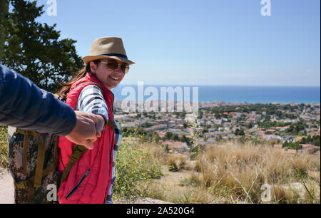 Ragazza passeggiate turistiche conduce un ragazzo dalla mano. follow me Foto Stock