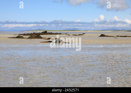 Vista da North Uist, attraverso le velme e sabbie umide a bassa marea, per l'isola di Vallay, nelle Ebridi Esterne della Scozia, Regno Unito Foto Stock