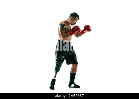 A piena lunghezza Ritratto di sportivo muscolare con gamba protesico, copia dello spazio. Boxer maschio in rosso i guanti. Colpo isolato su bianco di sfondo per studio. Foto Stock